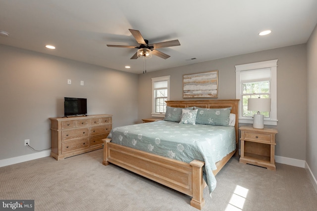 carpeted bedroom featuring multiple windows and ceiling fan