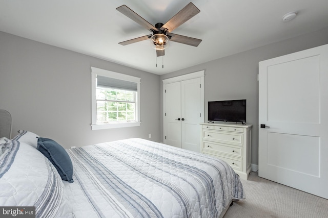 carpeted bedroom with ceiling fan and a closet