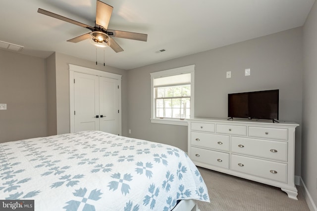 carpeted bedroom featuring ceiling fan and a closet