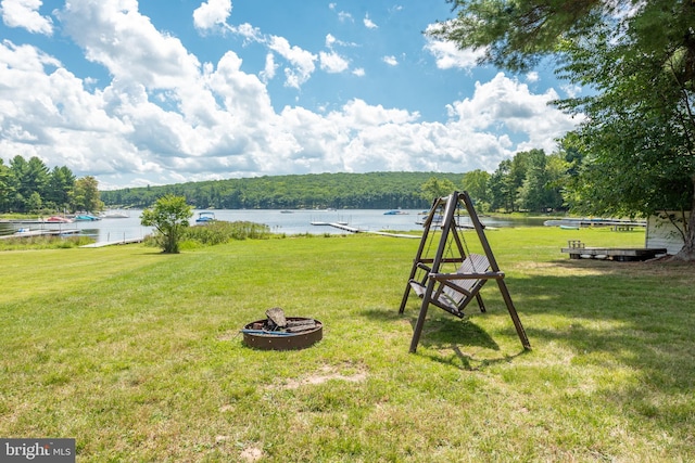 view of yard with a fire pit and a water view