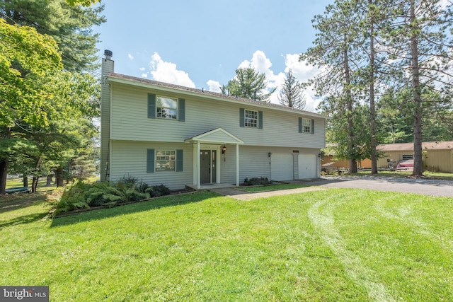 view of front of home with a front yard and a garage