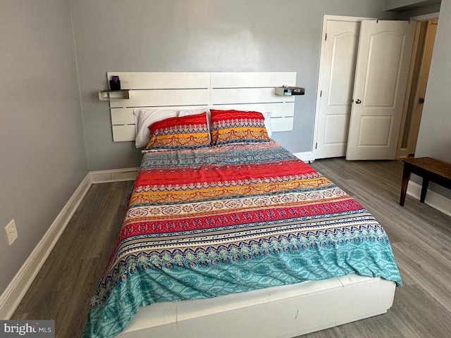 bedroom with dark hardwood / wood-style flooring