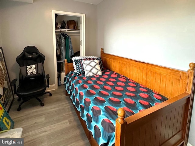 bedroom featuring hardwood / wood-style floors and a closet