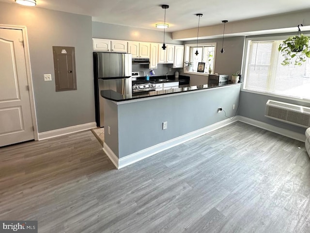 kitchen with white cabinets, decorative light fixtures, kitchen peninsula, and appliances with stainless steel finishes