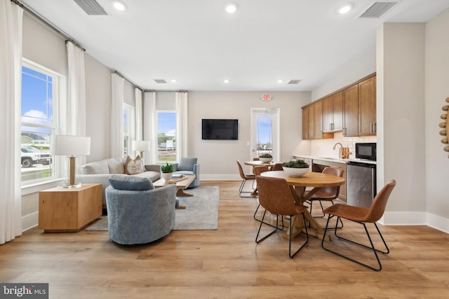 dining area with light hardwood / wood-style floors and sink