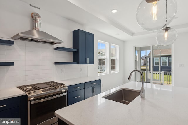 kitchen with light stone countertops, backsplash, island range hood, sink, and stainless steel range with gas stovetop