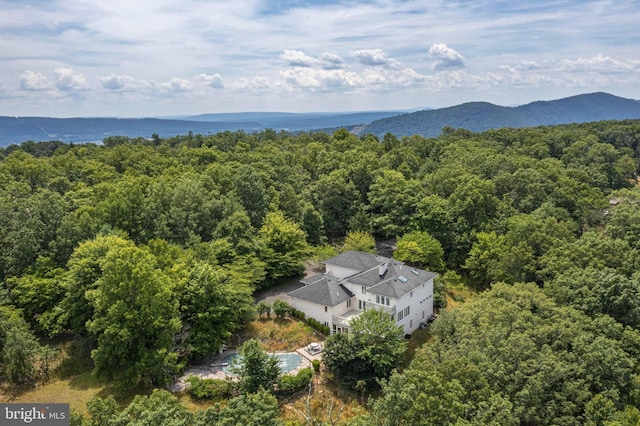 birds eye view of property with a mountain view and a wooded view