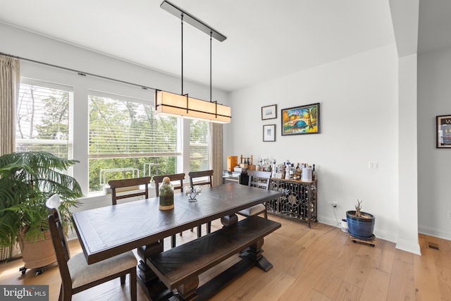 dining room with track lighting and light hardwood / wood-style floors