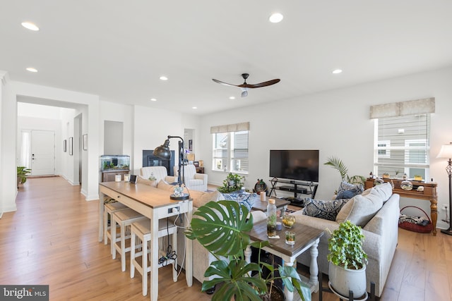 living room featuring light wood-type flooring and ceiling fan