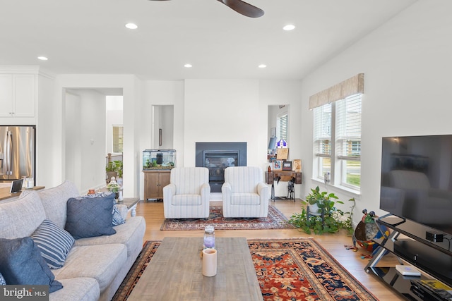 living room with ceiling fan and light wood-type flooring