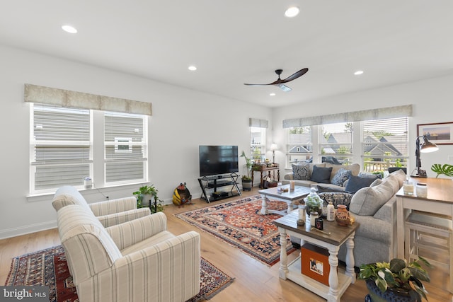 living room featuring ceiling fan and light hardwood / wood-style floors