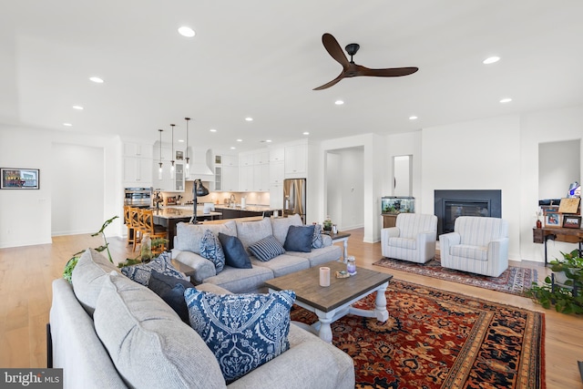 living room featuring light hardwood / wood-style flooring and ceiling fan