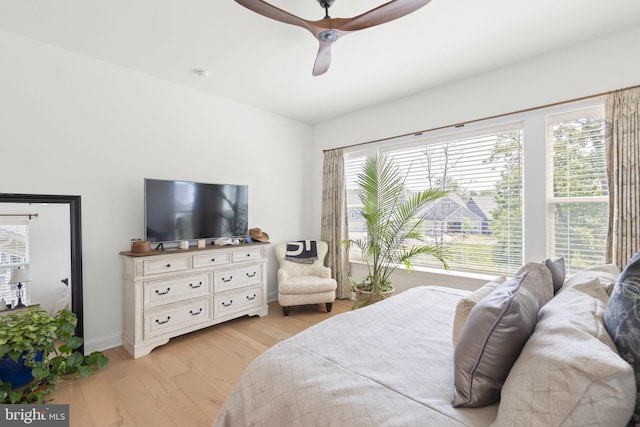 bedroom featuring multiple windows, ceiling fan, and light wood-type flooring