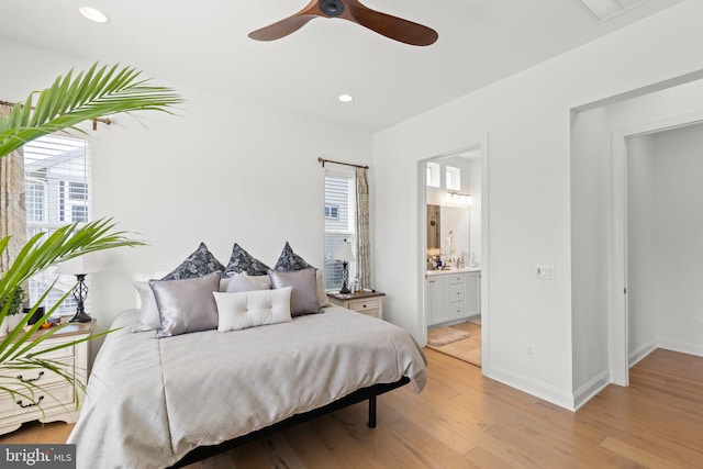 bedroom with connected bathroom, light wood-type flooring, and ceiling fan