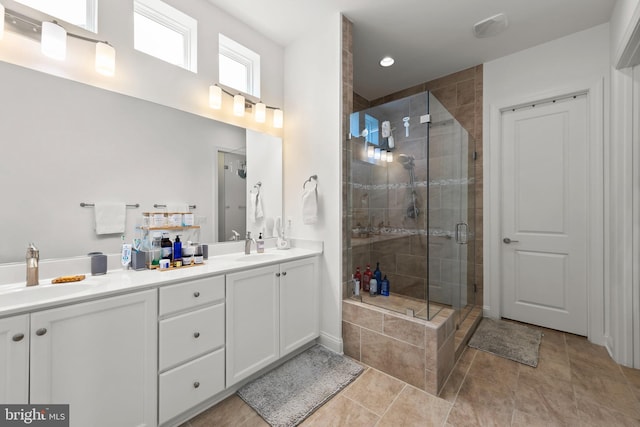 bathroom featuring a shower with door, tile patterned floors, and double sink vanity