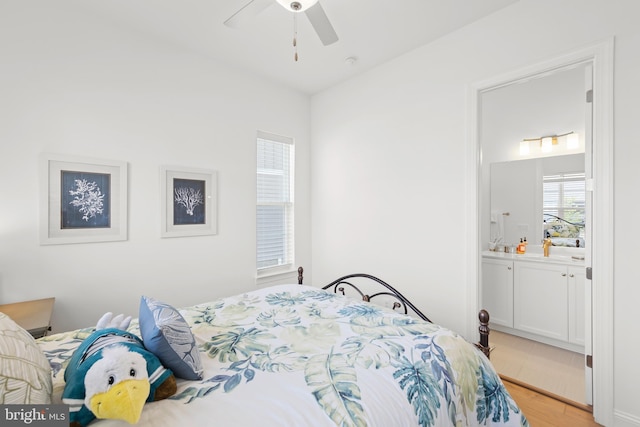 bedroom with light hardwood / wood-style floors, ensuite bath, and ceiling fan