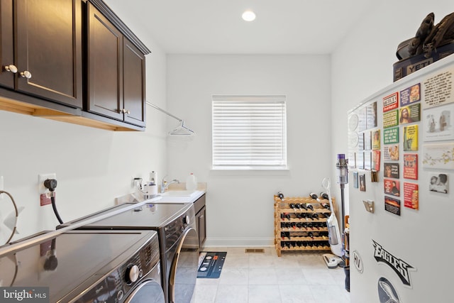 washroom with cabinets, separate washer and dryer, sink, and light tile patterned floors