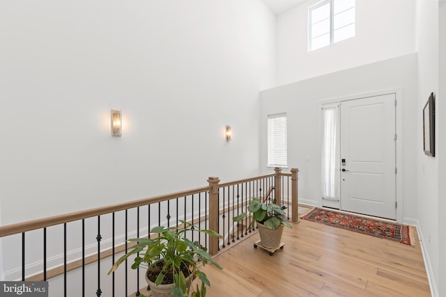 entrance foyer with light wood-type flooring and a towering ceiling