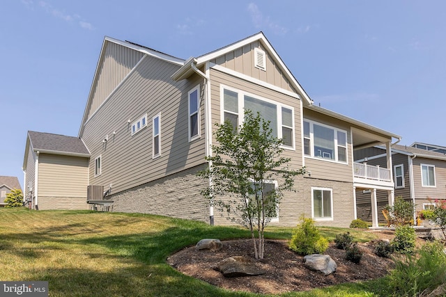 view of property exterior with a balcony and a lawn