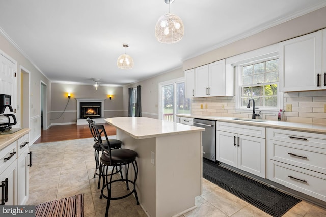 kitchen with decorative light fixtures, tasteful backsplash, sink, a kitchen island, and light tile patterned floors