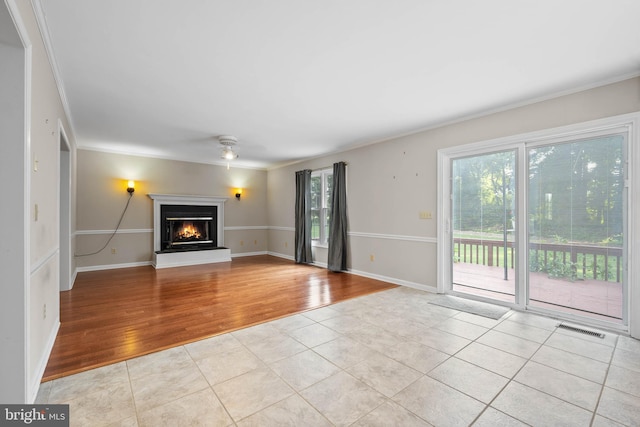 unfurnished living room with light tile patterned flooring, crown molding, and ceiling fan