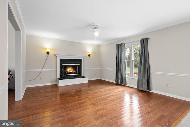 unfurnished living room with hardwood / wood-style flooring and crown molding