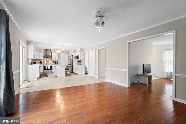 living room featuring light tile patterned flooring, ceiling fan, and crown molding