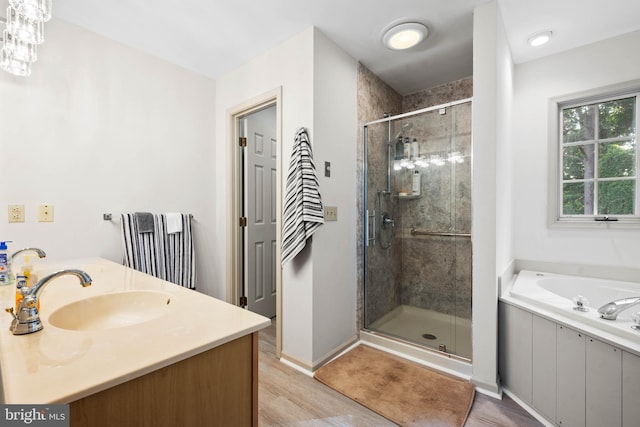 bathroom featuring independent shower and bath, wood-type flooring, and vanity