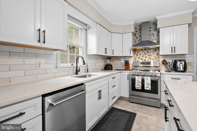 kitchen with light tile patterned flooring, tasteful backsplash, wall chimney exhaust hood, appliances with stainless steel finishes, and sink