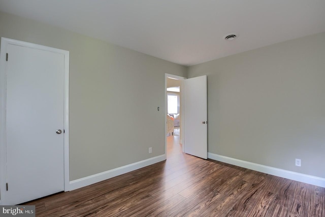 unfurnished room featuring dark hardwood / wood-style flooring