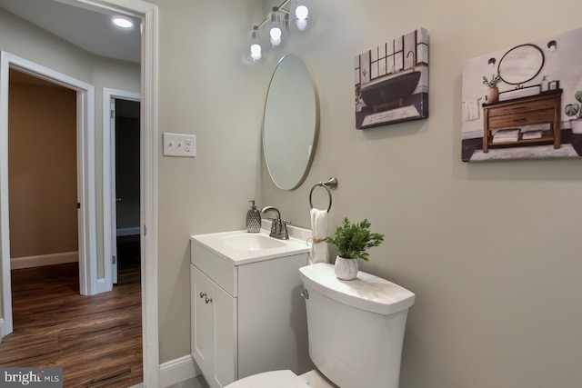 bathroom with vanity, hardwood / wood-style flooring, and toilet