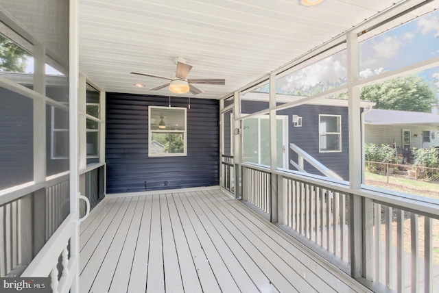 unfurnished sunroom with ceiling fan