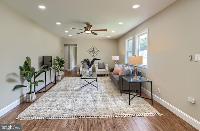 living room featuring dark hardwood / wood-style floors and ceiling fan