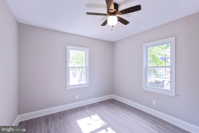 spare room featuring hardwood / wood-style flooring, a wealth of natural light, and ceiling fan