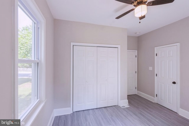 unfurnished bedroom with ceiling fan and light wood-type flooring