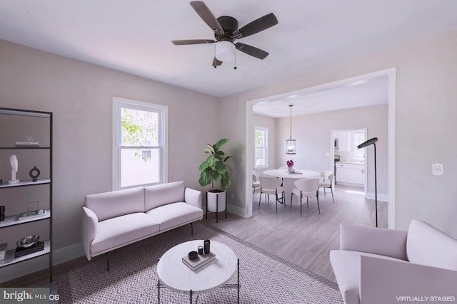 living room featuring wood-type flooring and ceiling fan