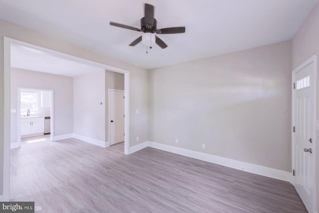 spare room with wood-type flooring, ceiling fan, and sink