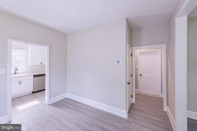 spare room with sink and light hardwood / wood-style flooring