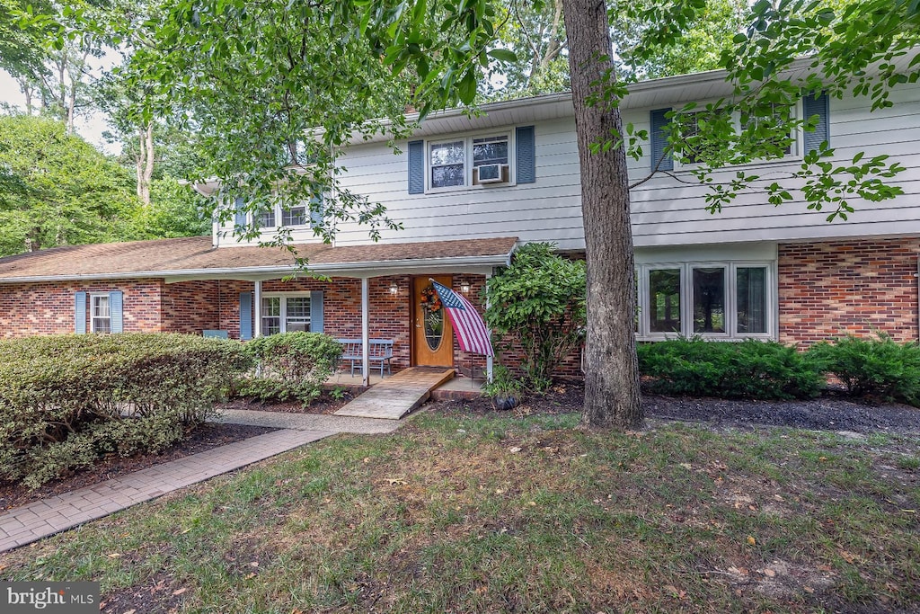 view of front of property featuring covered porch and cooling unit