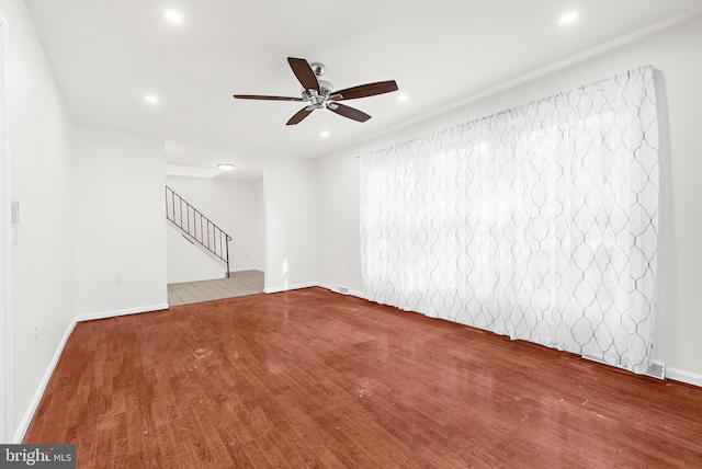 empty room with ceiling fan and light hardwood / wood-style floors