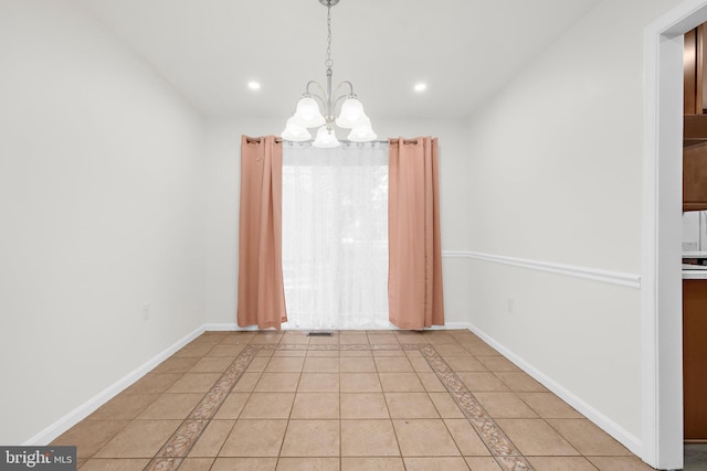 unfurnished dining area with light tile patterned floors and a chandelier