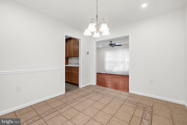 unfurnished dining area featuring ceiling fan with notable chandelier and light tile patterned floors