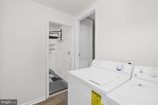 laundry room featuring washer and clothes dryer and wood-type flooring