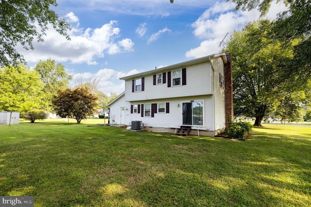 back of property featuring central AC unit and a lawn