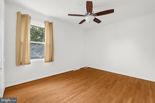 empty room with hardwood / wood-style floors and ceiling fan