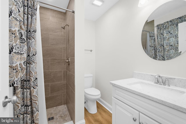 bathroom featuring walk in shower, vanity, toilet, and hardwood / wood-style floors