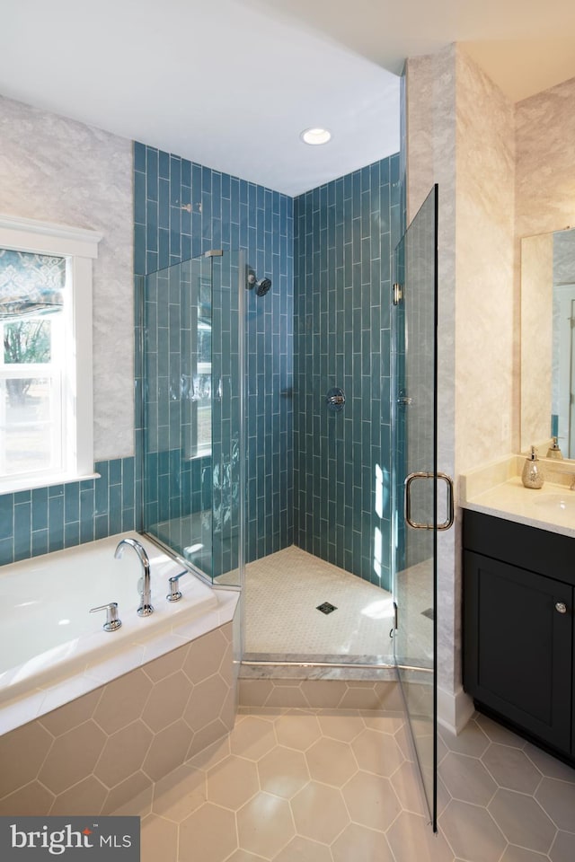 bathroom with tile patterned floors, vanity, tile walls, and independent shower and bath