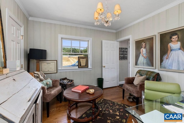 living area featuring wood-type flooring, ornamental molding, and a notable chandelier