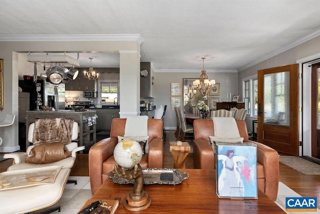 dining area with hardwood / wood-style flooring, a notable chandelier, sink, and crown molding