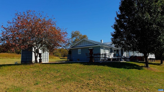 view of side of home featuring a yard and a storage unit